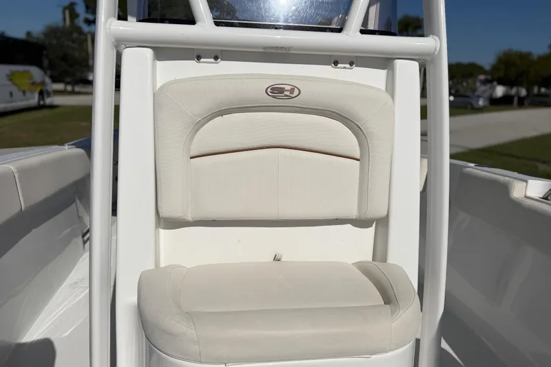Slide: The Image of 2021 Sea Hunt Ultra 234 boat seat with white upholstery and logo detail. - 24