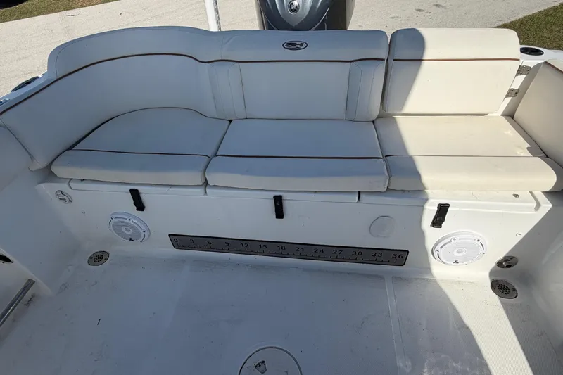 Slide: The Image of 2021 Sea Hunt Ultra 234 boat interior with cushioned seating and built-in speakers. - 25