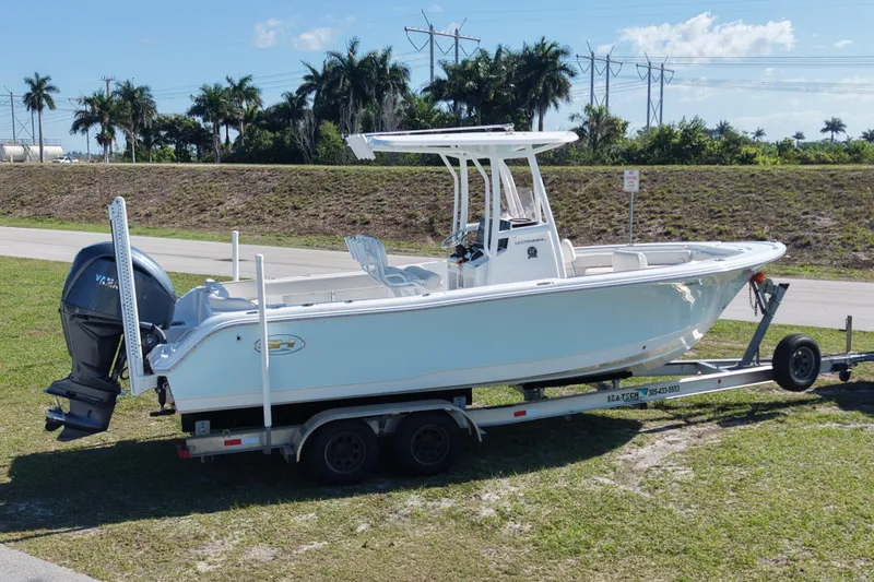 Slide: The Image of 2021 Sea Hunt Ultra 234 boat on trailer, parked outdoors under clear sky. - 6
