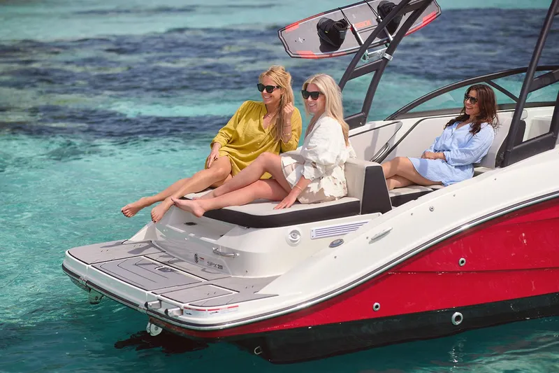 Slide: The Image of Manufacturer Provided Image: Three women relaxing on a 2025 Sea Ray SPX 210 boat in clear blue water. - 4