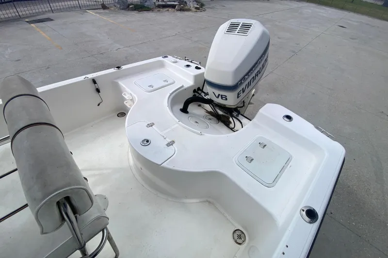 Slide: The Image of 2002 Century 2101 Bay Boat with Evinrude V6 engine, parked on concrete surface. - 16