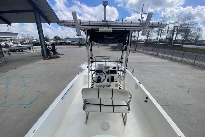 Slide: The Image of 2002 Century 2101 Bay Boat with T-top and console, parked outdoors under cloudy sky. - 21