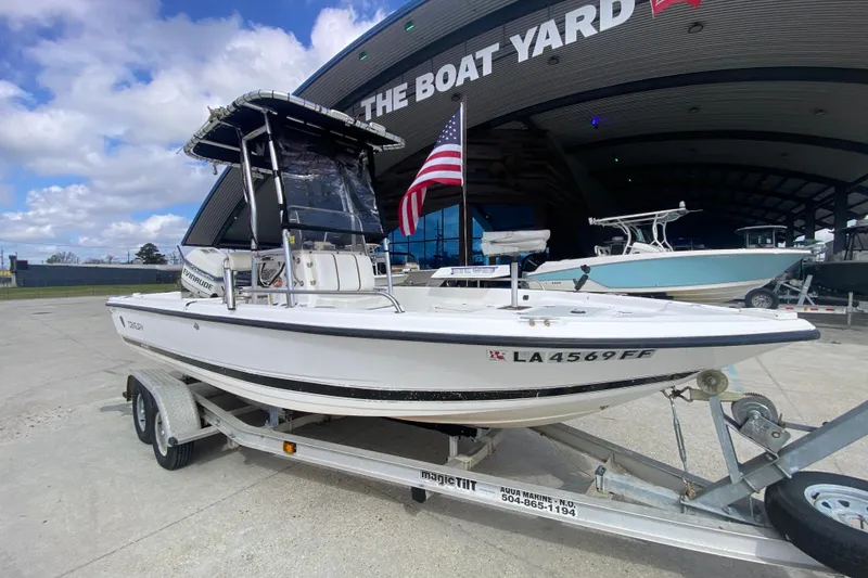 Slide: The Image of 2002 Century 2101 Bay Boat on trailer at The Boat Yard, featuring an American flag. - 6