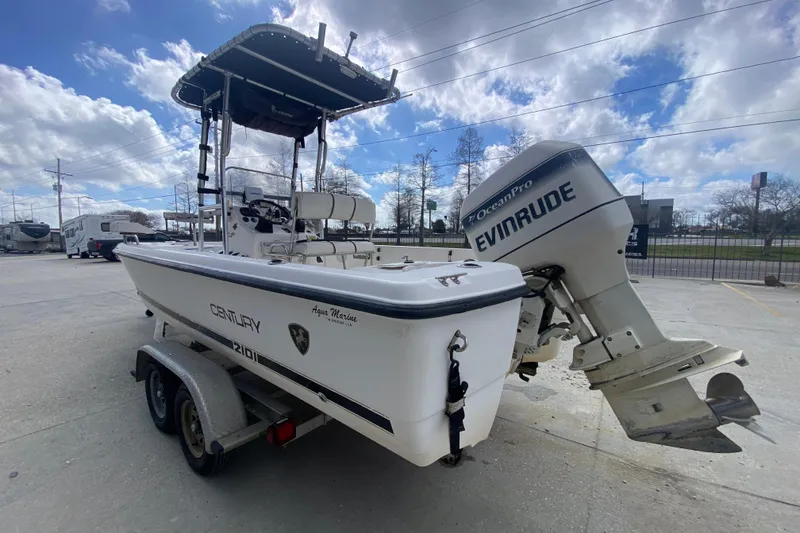 Slide: The Image of 2002 Century 2101 Bay Boat with Evinrude motor on trailer, parked outdoors. - 9