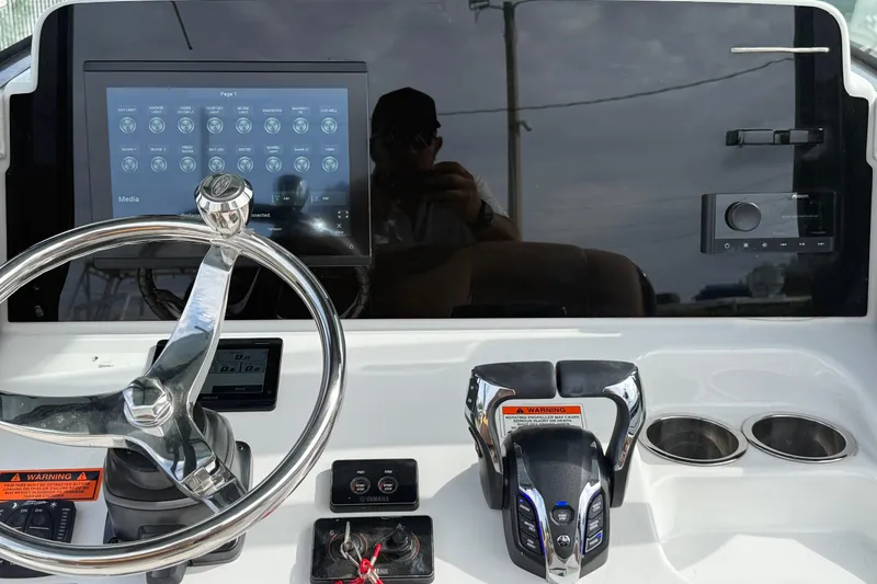 Slide: The Image of Control panel of 2022 Sea Hunt Ultra 265 SE boat with steering wheel and digital display. - 11
