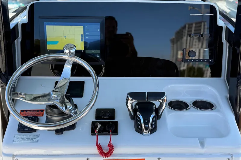 Slide: The Image of 2022 Sea Hunt Ultra 265 SE dashboard with steering wheel, touchscreen, and controls. - 12