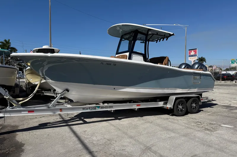 Slide: The Image of 2022 Sea Hunt Ultra 265 SE boat on trailer, parked outdoors under clear sky. - 3