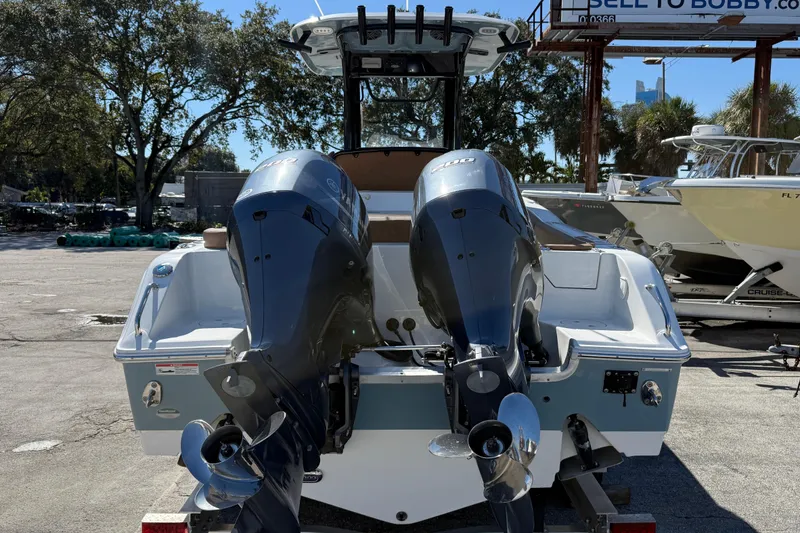 Slide: The Image of 2022 Sea Hunt Ultra 265 SE boat with dual outboard engines, parked outdoors. - 7