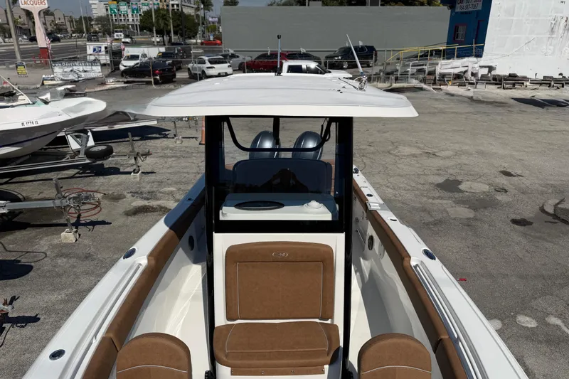 Slide: The Image of 2022 Sea Hunt Ultra 265 SE boat with brown seating, parked in a marina. - 8