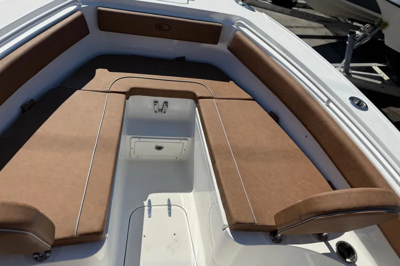Slide: The Image of 2022 Sea Hunt Ultra 265 SE boat interior with brown cushioned seating. - 9