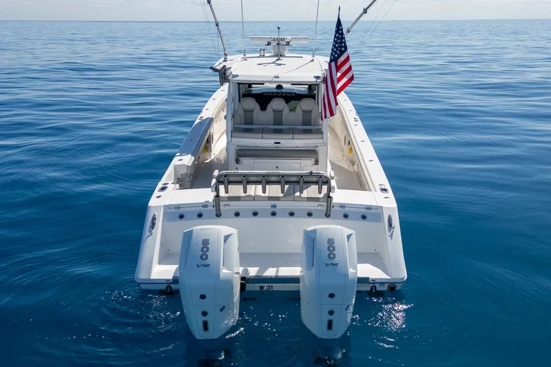 Slide: The Image of 2024 Solace 41 CS boat on calm ocean with dual engines and American flag. - 10