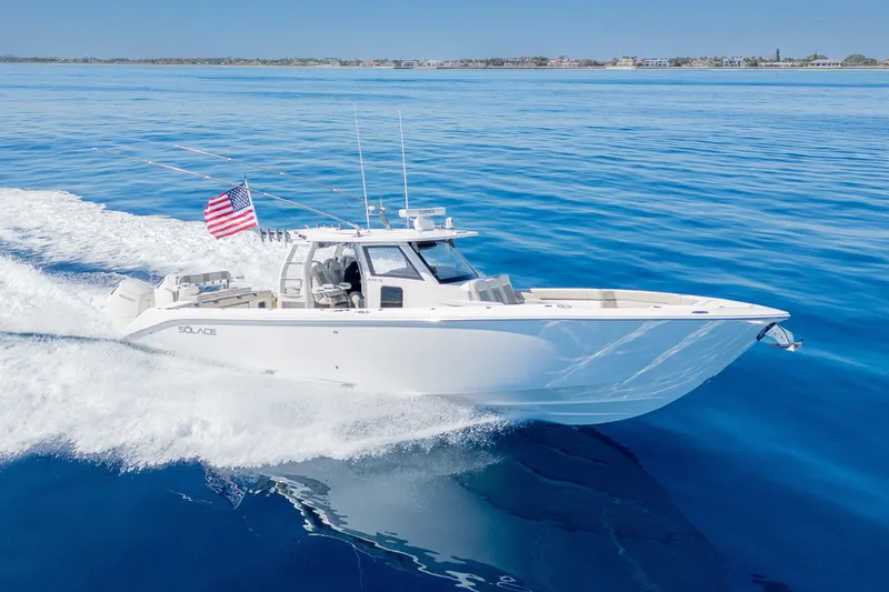 Slide: The Image of 2024 Solace 41 CS boat cruising on clear blue ocean with American flag. - 13