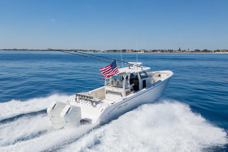 Slide: The Image of 2024 Solace 41 CS boat cruising on open water, American flag waving. - 14