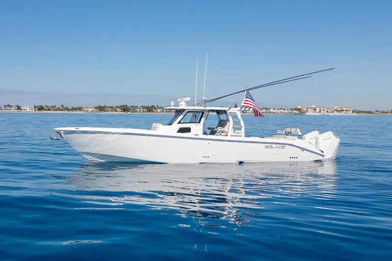 Slide: The Image of 2024 Solace 41 CS boat on calm blue water with American flag. - 2