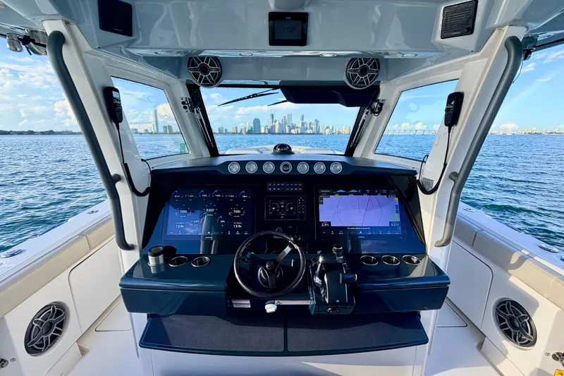 Slide: The Image of 2024 Solace 41 CS boat cockpit with advanced navigation system, overlooking city skyline and ocean. - 21