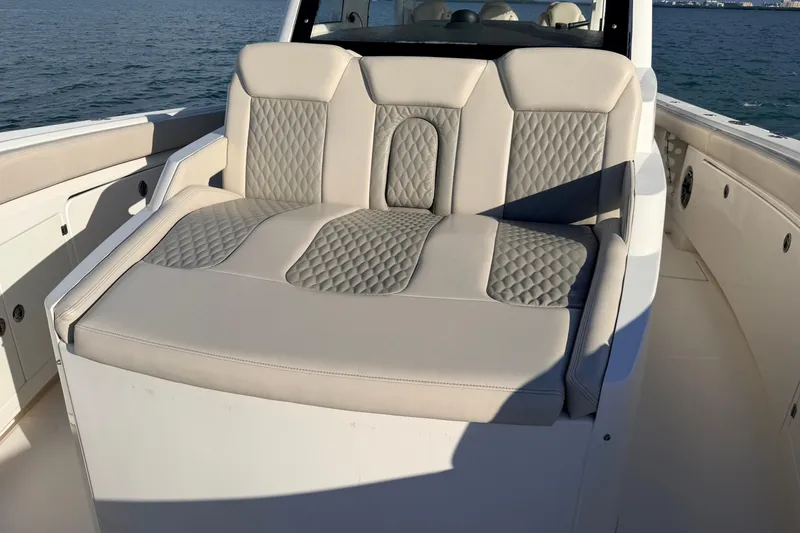 Slide: The Image of Luxurious seating on 2024 Solace 41 CS boat, featuring quilted upholstery and ocean backdrop. - 38