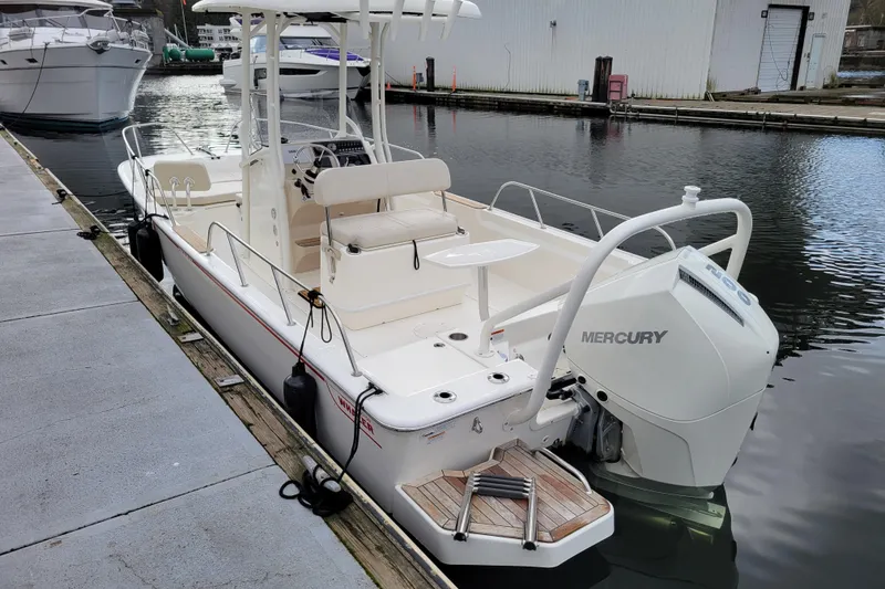 Slide: The Image of 2023 Boston Whaler 210 Montauk boat docked with Mercury engine. - 2