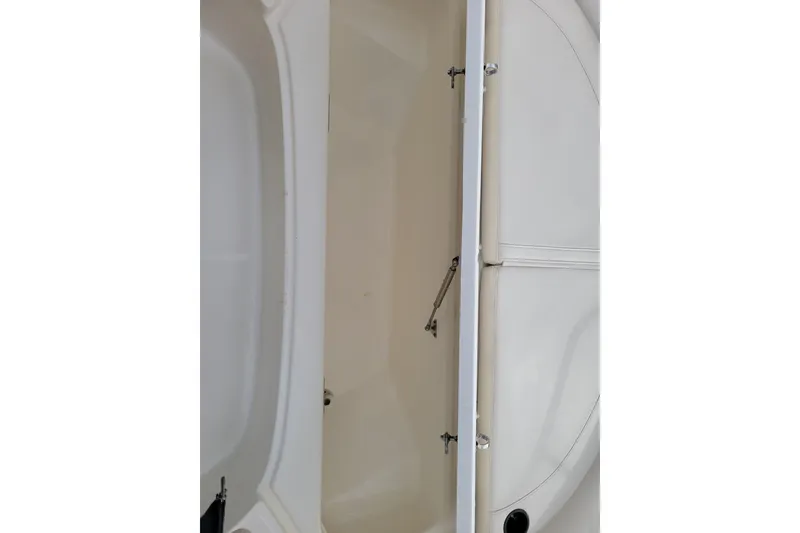 Slide: The Image of 2023 Boston Whaler 210 Montauk storage compartment, open and empty, showcasing interior space. - 24