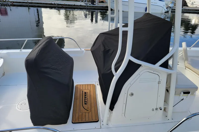 Slide: The Image of 2023 Boston Whaler 210 Montauk boat interior with covered seats at marina. - 27