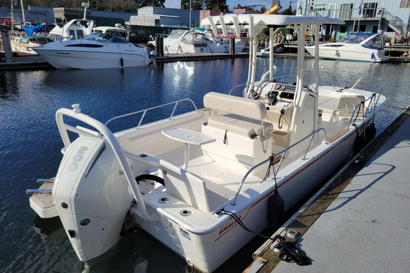 Slide: The Image of 2023 Boston Whaler 210 Montauk boat docked at marina, showcasing sleek design and powerful engine. - 4