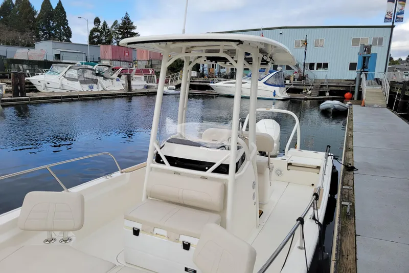 Slide: The Image of 2023 Boston Whaler 210 Montauk boat docked at marina with other vessels. - 8