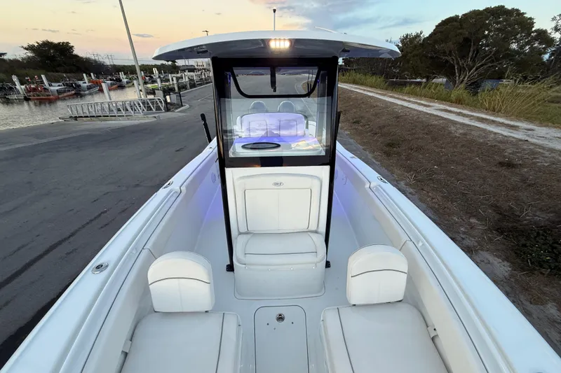 Slide: The Image of 2023 Sea Hunt Ultra 265 SE boat interior at sunset, docked near a marina. - 14