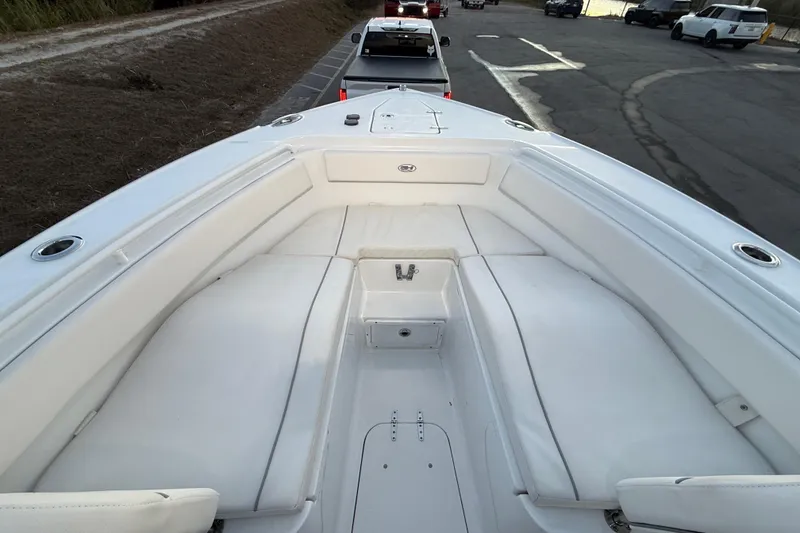 Slide: The Image of 2023 Sea Hunt Ultra 265 SE boat with spacious white seating area. - 15