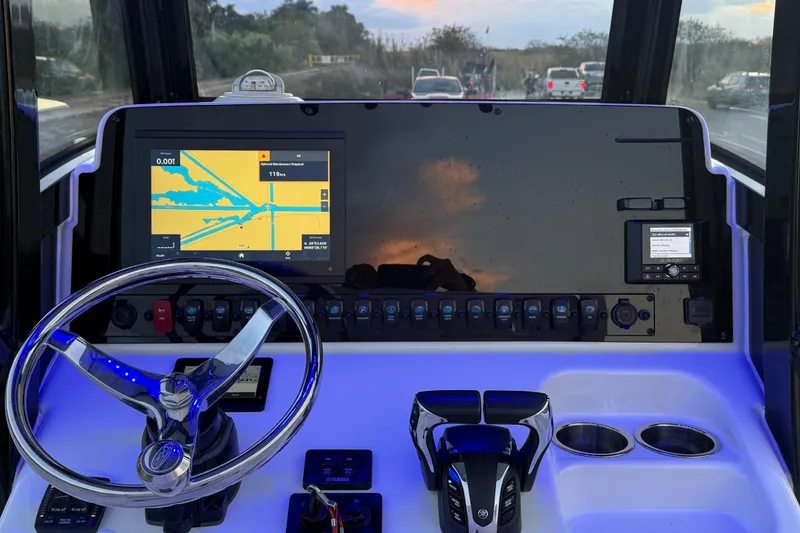 Slide: The Image of 2023 Sea Hunt Ultra 265 SE boat dashboard with navigation display and steering wheel. - 19
