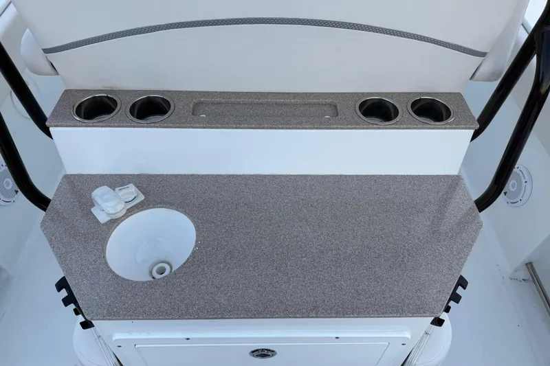 Slide: The Image of 2023 Sea Hunt Ultra 265 SE boat interior with sink and cup holders. - 22