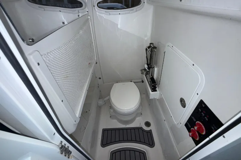 Slide: The Image of 2023 Sea Hunt Ultra 265 SE boat interior bathroom with toilet and storage. - 28