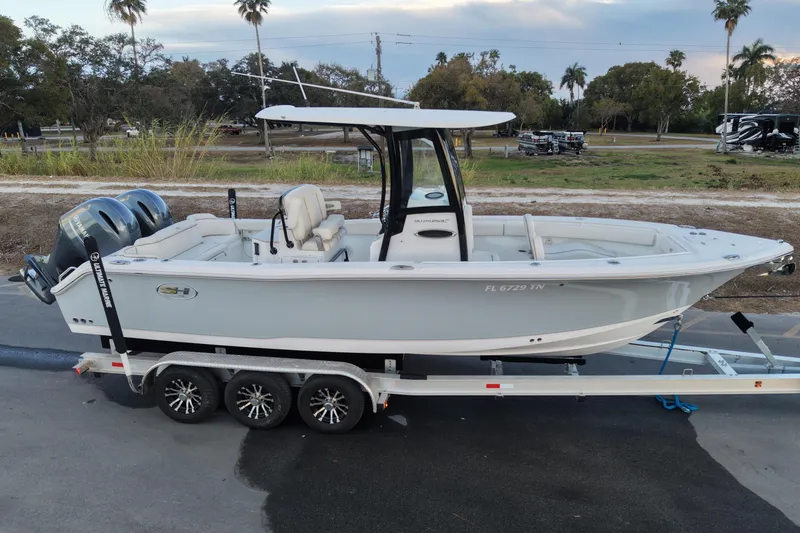 Slide: The Image of 2023 Sea Hunt Ultra 265 SE boat on trailer, parked outdoors with palm trees in background. - 3