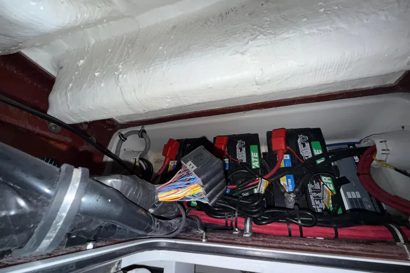 Slide: The Image of 2023 Sea Hunt Ultra 265 SE boat battery compartment with wiring and connections. - 32