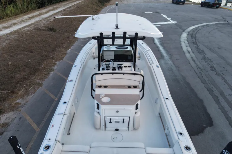 Slide: The Image of 2023 Sea Hunt Ultra 265 SE boat at dock, showcasing helm and seating area. - 6