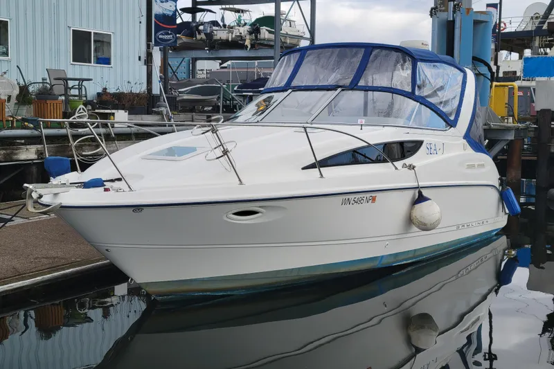 The Image of 2004 Bayliner 285 boat docked at marina, featuring blue canopy and sleek design. - 0