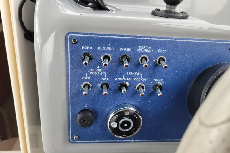 Slide: The Image of Control panel of a 2004 Bayliner 285 boat with various switches and dials. - 12