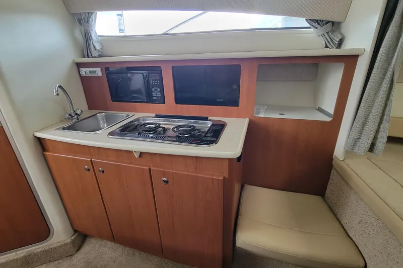 Slide: The Image of Open wooden cabinet with drawers in a 2004 Bayliner 285 boat interior. - 19