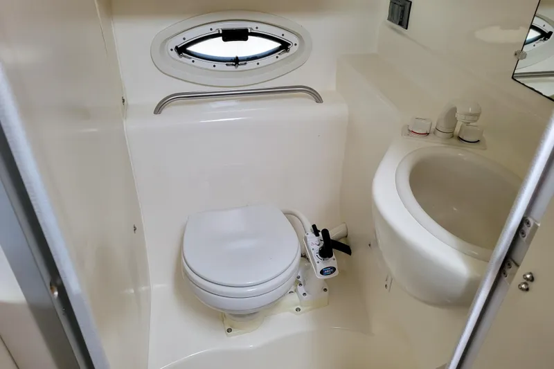 Slide: The Image of Interior cabin of 2004 Bayliner 285 boat with striped bedding and porthole windows. - 23