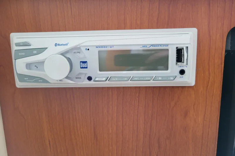 Slide: The Image of 2004 Bayliner 285 cabin interior with striped bedding and a small window. - 27