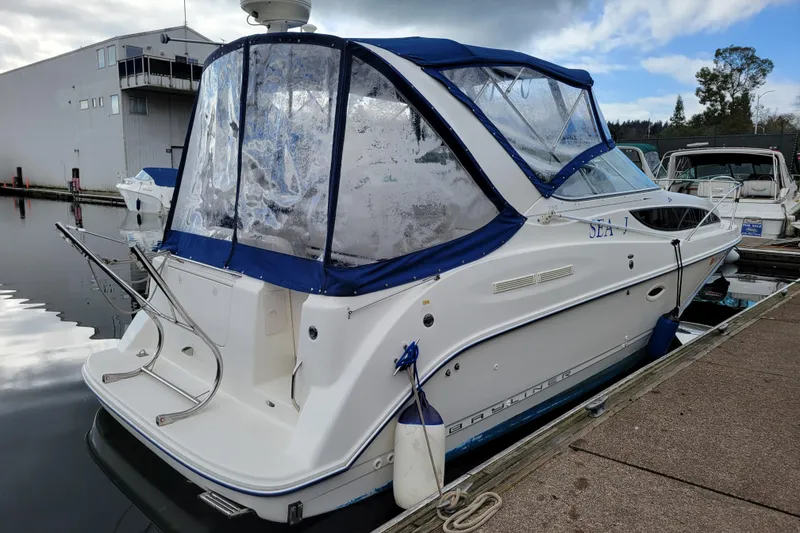 Slide: The Image of 2004 Bayliner 285 boat docked, featuring blue canopy and sleek design. - 3