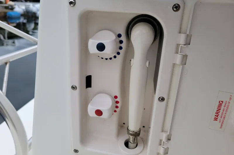 Slide: The Image of 2004 Bayliner 285 boat shower controls with temperature knobs and hose. - 34