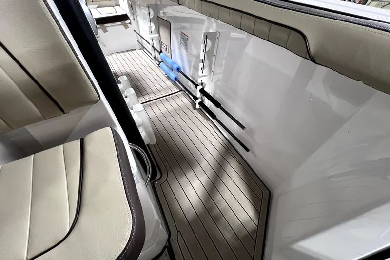 Slide: The Image of 2023 Yamaha Boats 255 FSH Sport E interior with cushioned seating and sleek flooring. - 10