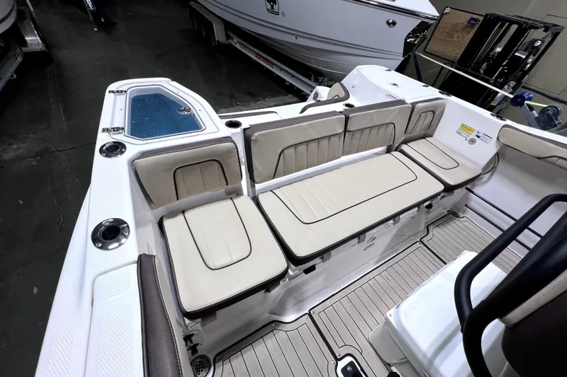 Slide: The Image of 2023 Yamaha Boats 255 FSH Sport E interior with beige seating and storage compartments. - 13