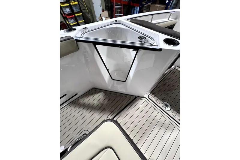 Slide: The Image of 2023 Yamaha Boats 255 FSH Sport E interior with sleek deck and storage compartment. - 15