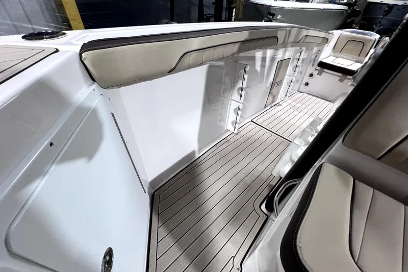 Slide: The Image of 2023 Yamaha Boats 255 FSH Sport E interior with cushioned seating and sleek flooring. - 19