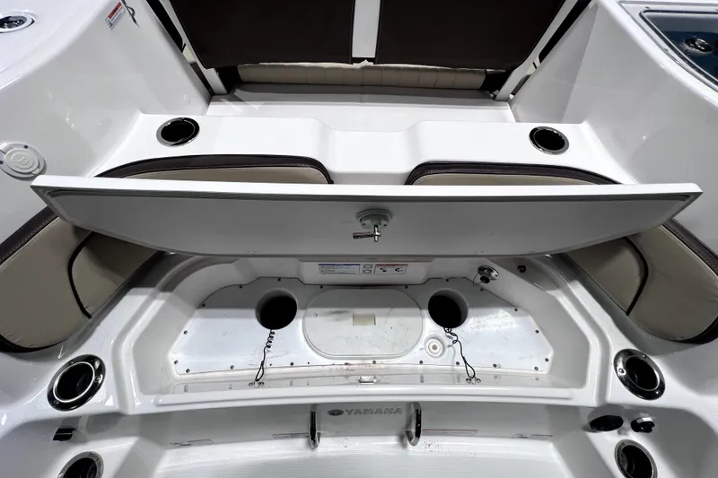 Slide: The Image of 2023 Yamaha Boats 255 FSH Sport E interior storage compartment with cup holders and seating. - 21