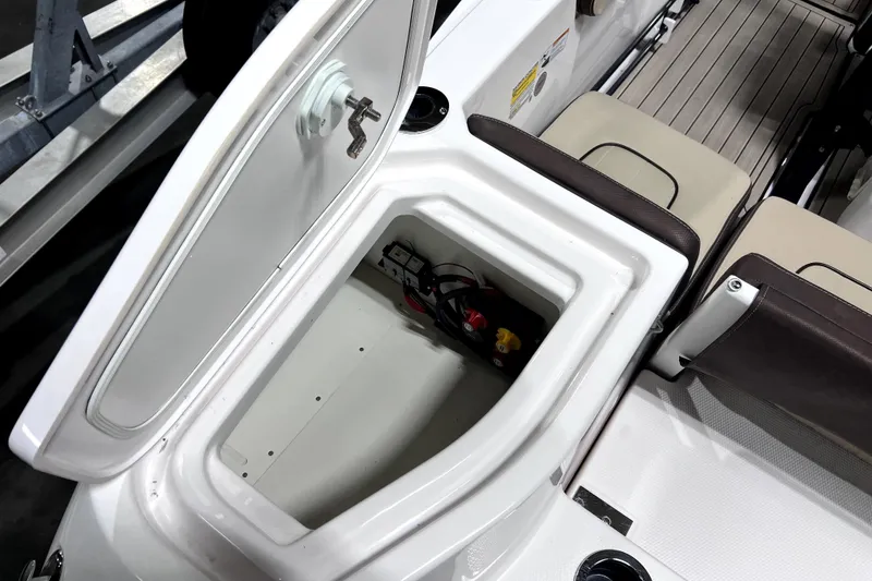 Slide: The Image of 2023 Yamaha Boats 255 FSH Sport E storage compartment with open hatch and seating area. - 22