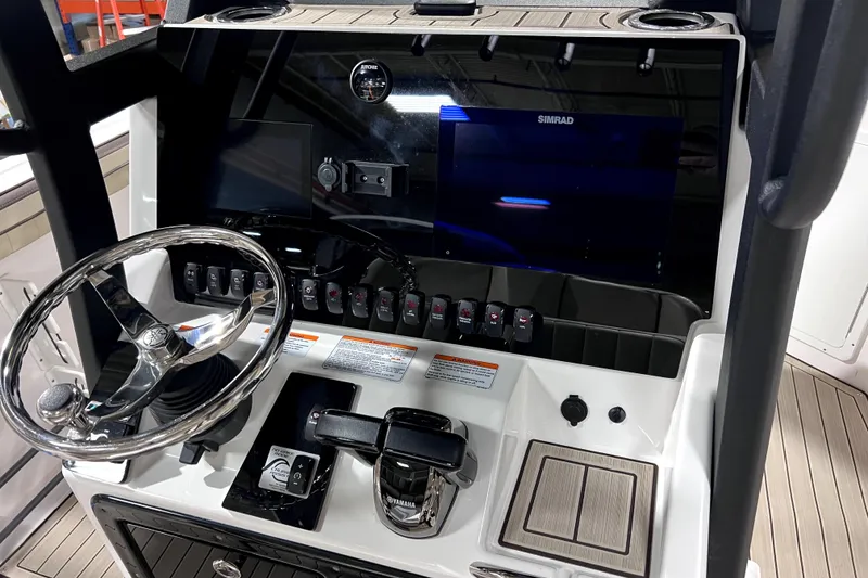 Slide: The Image of 2023 Yamaha Boats 255 FSH Sport E dashboard with steering wheel and controls. - 9
