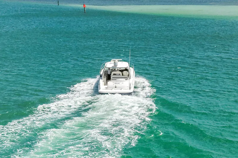 Slide: The Image of 2004 Sea Ray 420 Sundancer cruising on turquoise waters, leaving a wake behind. - 10