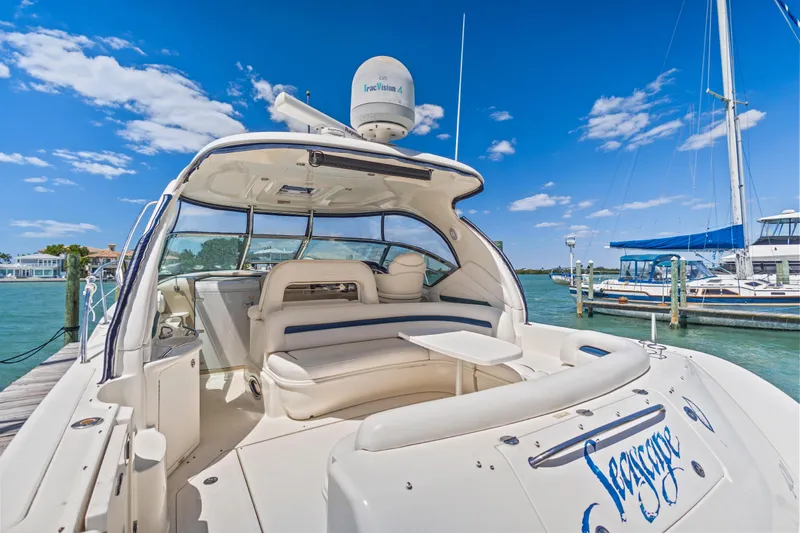 Slide: The Image of 2004 Sea Ray 420 Sundancer yacht docked, featuring spacious seating and clear blue skies. - 12