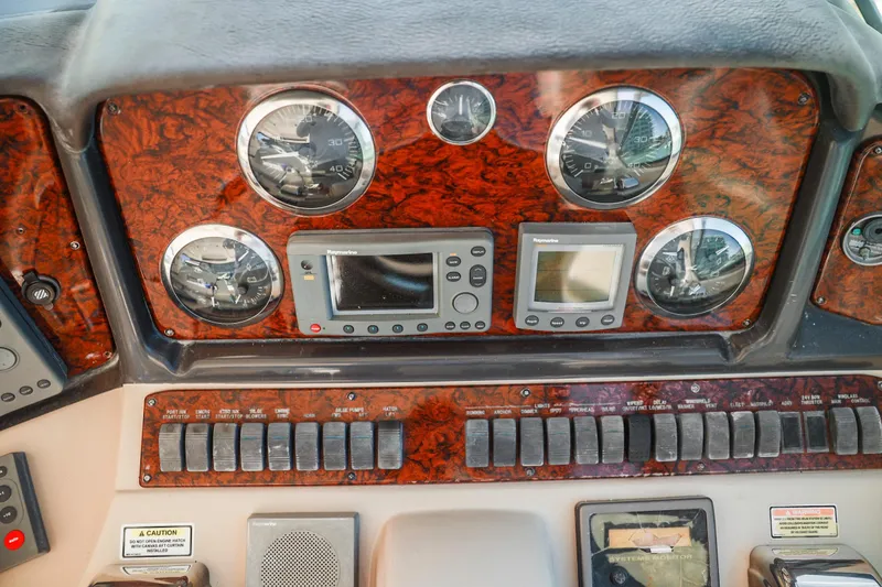 Slide: The Image of Dashboard of a 2004 Sea Ray 420 Sundancer with gauges and controls. - 26